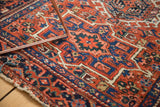 Detail of a vintage Karaja rug's brick red geometric pattern and original looped fringe.