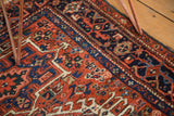 Hand-knotted vintage Karaja rug section with brick red field and navy blue geometric motifs.