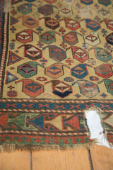 Antique Caucasian runner, close-up of geometric boteh pattern, worn pile, and large hole.