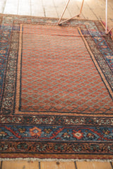 Vintage Hamadan runner's abrash grapefruit red ain field and intricate blue palmette borders.