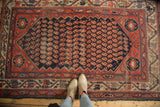 Antique Hamadan rug featuring an allover boteh pattern and visible, mostly even wear.