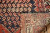Antique Hamadan rug showing worn navy boteh pile, exposed edge, and woven back foundation.