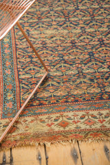 Antique Kurdish runner's geometric border with madder red and blue, showing tattered end and visible foundation.