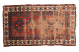 Antique Caucasian rug, geometric medallion, rich texture, dusty brick red, navy, and ivory palette.