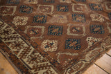 Antique Yomud hand-knotted carpet displaying geometric panels, bronze hues, and aged patina.