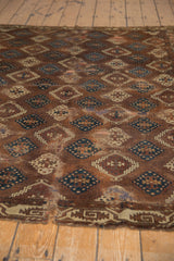 Worn edge of antique Yomud carpet shows geometric border, tatter, and historical mending.