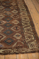 Antique Yomud carpet close-up: unique geometric border and staggered field in bronze, teal, ivory.