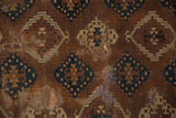 Antique Yomud carpet close-up: storied wear, mending, and geometric patterns in bronze, teal, ivory.