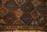 Antique Yomud carpet close-up: bronze, teal, copper geometric panels, unusual border, historic mending.