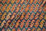 Antique Caucasian rug with indigo and madder root red geometric serpent motif, revealing a small hole.