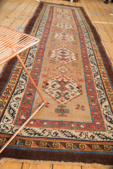 Antique Serab rug runner showing geometric medallions, starbursts, and complex aubergine-accented borders.