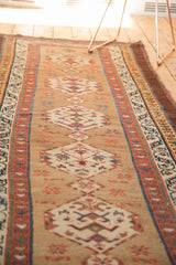 Antique Serab runner's natural camel field, featuring geometric medallions and rare aubergine border.
