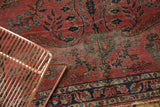 Antique Lilihan rug detail: dusty raspberry field, navy vinery, visible foundation, frayed edge.