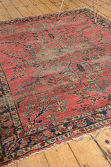 Antique Lilihan rug close-up reveals intricate floral vinery, dusty raspberry field, and aged fringe.