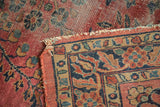 Detailed view of antique Lilihan rug border: intricate floral vinery, red, navy, and tattered edge.