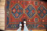 Antique Caucasian rug field with geometric crab and serpent motifs in cherry red, sky blue.