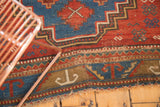 Stepped geometric patterns on antique Caucasian rug border with light tattered fringe.