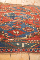 Antique Caucasian rug, cherry red and sky blue geometric patterns showing pile wear.