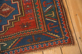 Antique Caucasian rug corner, with red, green, blue geometric borders and stylized serpent motifs.
