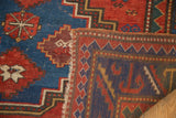 Antique Caucasian rug corner with geometric pattern, lightly tattered fringe, and woven reverse.