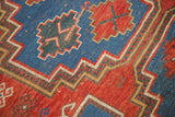 Intricate sky blue, cherry red, and beige geometric borders on an antique Caucasian rug.