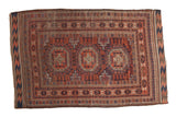 Antique Belouch rug with triple geometric medallions, layered borders, and chevron kilim ends.