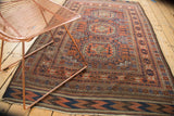 Antique Belouch tribal rug corner, layered geometric borders in copper bronze and navy.