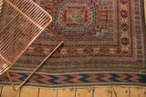 Antique Belouch rug end showing chevron kilim and geometric borders in copper and navy.