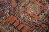 Antique Belouch rug's chevron and geometric patterns in rich copper and deep navy.