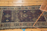 Antique Belouch rug end, displaying geometric guls, tattered fringe, and visible foundation wear.