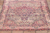 Blanched antique Kerman rug with soft rose and deep navy floral medallion.