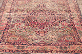 Blanched ivory, soft red, and muted blue intricate floral patterns on an antique Persian rug.