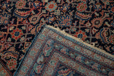 Folded antique Mahal rug showing its hand-knotted back, intricate Herati design, and unique powder blue selvage.