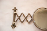 Circular beveled glass and aged metal frame of the antique shaving mirror.