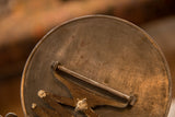 Aged brass back of the antique accordion shaving mirror with Weber-Knapp inscription.