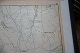 Black frame and white mat bordering the vintage Armonk map's aged paper.