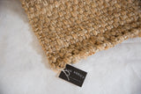 Chunky natural fiber weaving and textured edge of the Saratoga Jute rug.