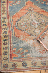 Textured wear on Vintage Distressed Oushak rug, with faded rust spandrel and abrashed slate blue field.