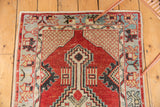 Distressed geometric medallion with stemmed finial and cross-hatched spandrel on cherry red Oushak rug.