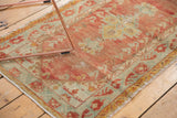 Vintage Distressed Oushak rug displaying worn pile, palmette motifs, faded red and seafoam green.