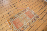 Distressed Oushak rug with worn texture, faded rust, bronze, and ivory leaf motifs.