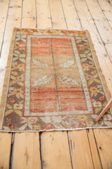 Corner detail of distressed vintage Oushak rug showing aged texture and floral border.