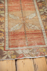 Distressed vintage Oushak rug field showing worn texture, rustic orange, and light foundation.