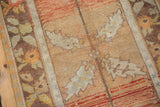 Distressed Oushak rug's worn pile, light foundation showing, in rust and ivory tones.