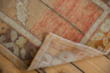 Distressed Oushak rug corner revealing rustic orange field, floral border, and hand-knotted foundation.