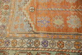 Distressed Oushak rug corner with stepped zig-zag spandrel, geometric palmettes, and floral border.