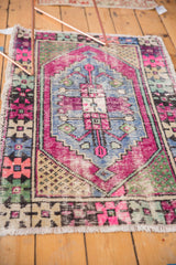 Vibrant bubble gum pink distressed texture on vintage Oushak rug corner with fringe.