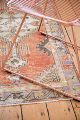 Distressed Oushak runner showcasing faded cherry red field, geometric border, and soft patina.