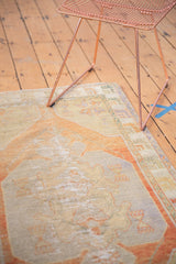Distressed texture of vintage Oushak rug, showing pale terra cotta, sand, and blue.