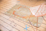 Textural view of distressed vintage Oushak rug, showcasing faded terra cotta, blue, and ivory tones.